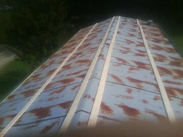 Rusted metal roof panels with new wood purlins before replacement — Storm Damage Roof Repair in Pocasset by Roofing Brothers